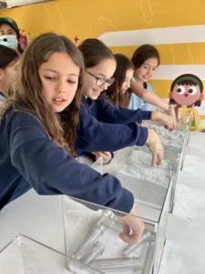 Niñas participando en una actividad educativa de reciclaje y sustentabilidad en un espacio de TEM Turistik.