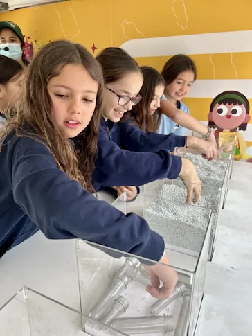 Niñas participando en una actividad educativa de reciclaje y sustentabilidad en un espacio de TEM Turistik.