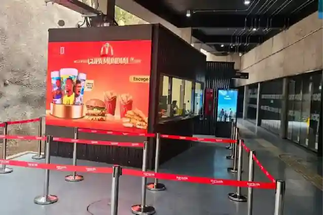 Módulo de atención y boletería con publicidad de comida rápida delimitado por vallas en la estación Pío Nono de TEM Turistik.