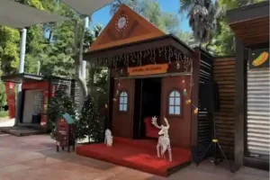 Cabaña navideña decorada con luces y figuras de renos en una atracción temática de TEM Turistik.