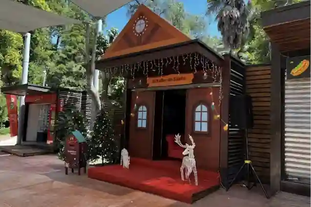 Cabaña navideña decorada con luces y figuras de renos en una atracción temática de TEM Turistik.