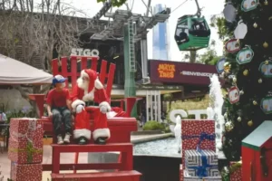 Niño sentado junto a Papá Noel en un gran sillón rojo rodeado de regalos y un árbol de Navidad en TEM Turistik.