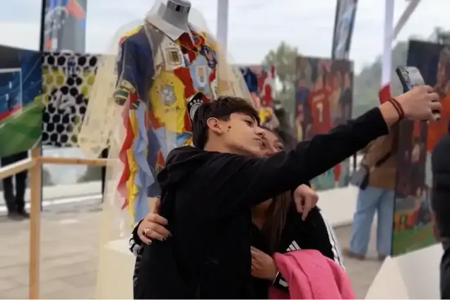 Jóvenes tomándose una selfi abrazados junto a una exhibición de arte deportivo en TEM Turistik.